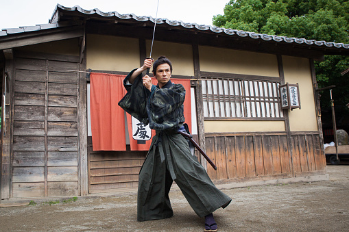 A real Japanese Samurai arms himself for battle with a samurai sword