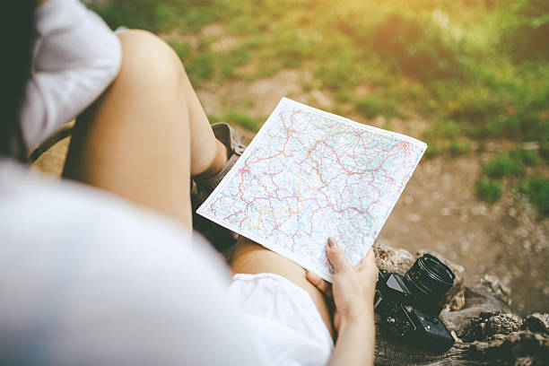 istock woman holding a map in the park 539979966
