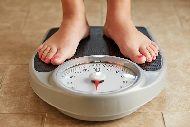 istock Female feet on a bathroom scale 539980334