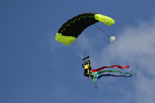 Skydiver with South African flag coming into land