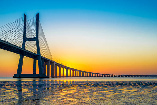 Vasco da Gama Bridge at sunrise Vasco da Gama Bridge at sunrise, Lisbon, Portugal suspension bridge stock pictures, royalty-free photos & images