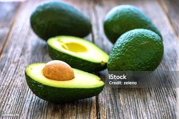 Avocado On Wooden Background Stock Photo - Download Image Now - Avocado, Backgrounds, Brown