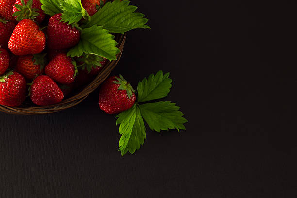 istock strawberry  in a wicker basket on a dark background 539984390