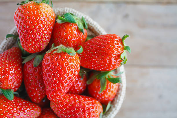 istock strawberries in small sack on wooden table background 539989302