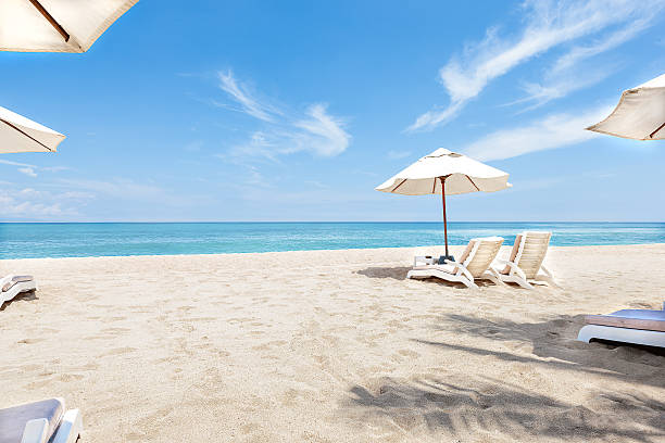 istock Ocean side chairs and umbrellas with blue sky 539990130