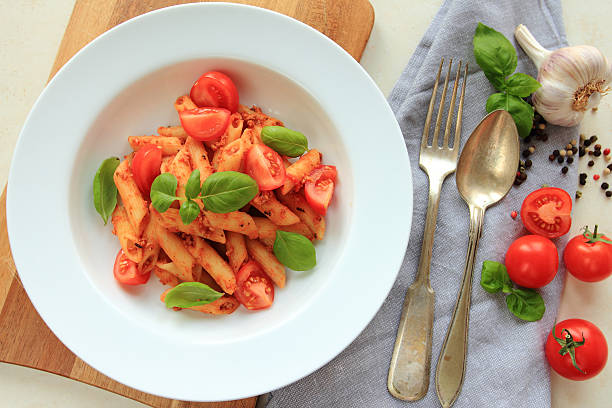 Penne pasta with fresh basil stock photo