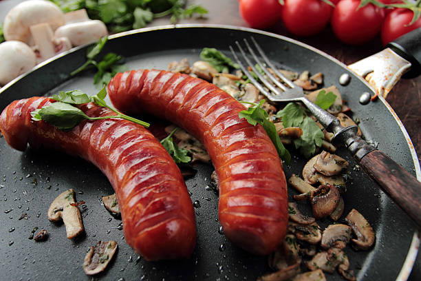 Grilled sausages with mushrooms stock photo