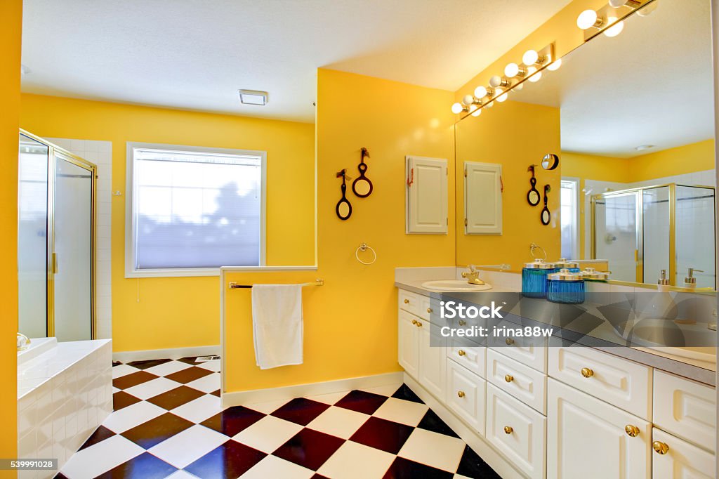 Bright yellow bathroom interior with white cabinets, tile. Bright yellow bathroom interior with white cabinets, tile, big mirror and glass shower Bathroom Stock Photo