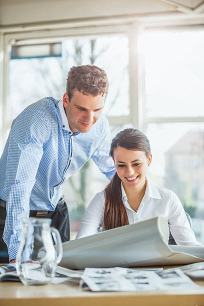 istock Young architects looking at blueprint at office desk 540089108