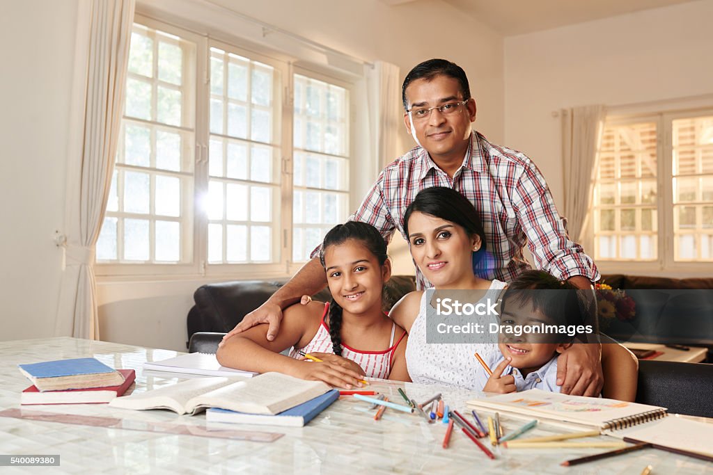 Studying together Parents helping their children in study at home Family Stock Photo