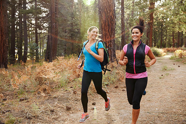 istock Two young women running in a forest, close up 540090416