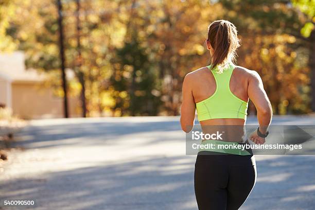 Caucasian Woman Jogging On Country Road Back View Close Up Stock Photo - Download Image Now