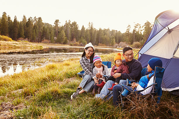 asiatische familie auf einen camping-trip, entspannen sie sich vor ihrem zelt - sibling brother family with three children sister stock-fotos und bilder