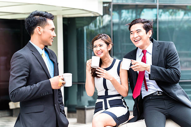 istock Asian businesspeople drinking coffee outside 540093122