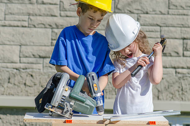 Little boy and girl playing with big tools outside