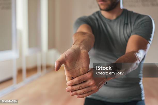 Sporty Man Stretching Forearm Before Gym Workout Stock Photo - Download Image Now - Stretching, Exercising, Relaxation Exercise