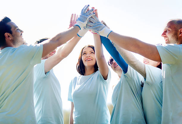 istock group of happy volunteers making high five in park 540094934