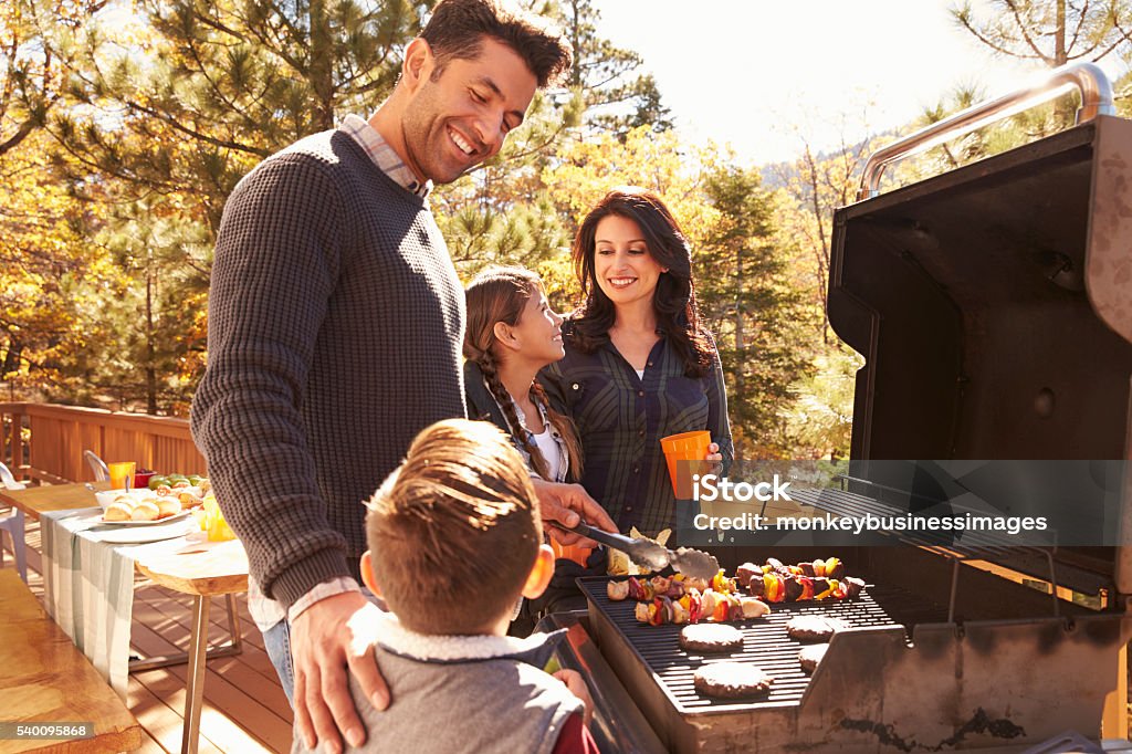 Family barbecuing on a deck in the forest Family Stock Photo