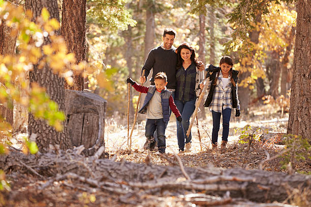 feliz familia hispana con dos niños caminando en un bosque - excursionismo fotografías e imágenes de stock