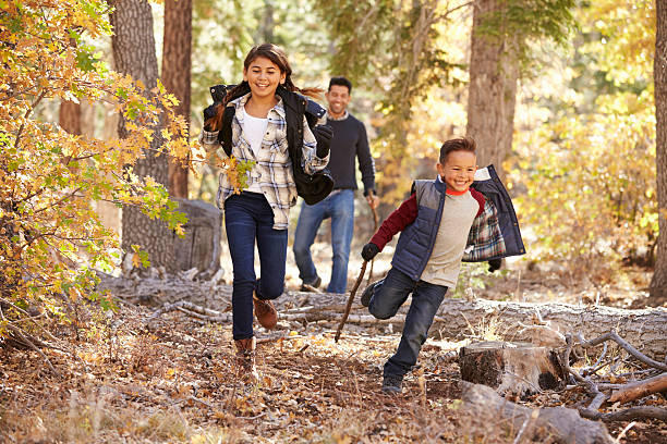 istock Children in a forest running to camera, father looking on 540095986