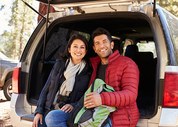 istock Happy Hispanic couple sitting in open back of car 540096080