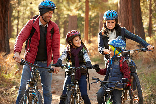 istock Hispanic family on bikes in a forest looking at each 540096280