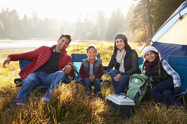 istock Happy family on a camping trip sit by tent looking 540096378