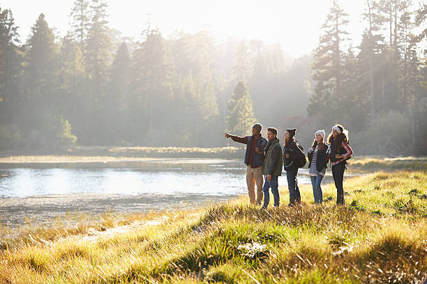 istock Five friends walking near a lake take in view, one 540096472