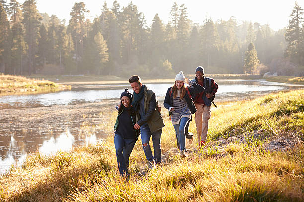 istock Four friends having fun walking beside a lake 540096492