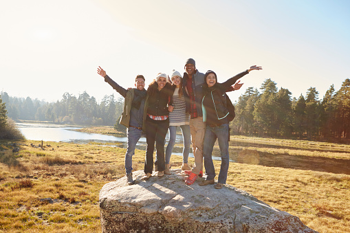 Portrait of five friends standing on a rock in countryside