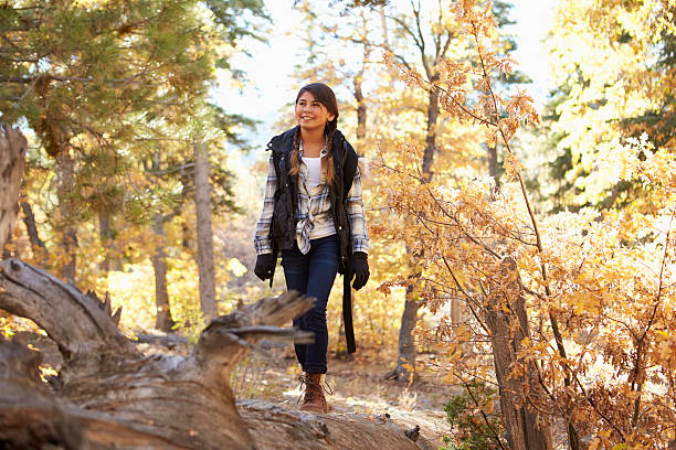 istock Hispanic girl walking along a fallen tree in a forest 540096616