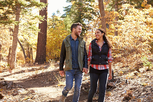 pareja caminando en un bosque suspender las manos y analizar cada uno - couple young adult african descent multi ethnic group fotografías e imágenes de stock