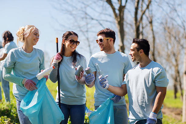 volunteers with garbage bags cleaning park area