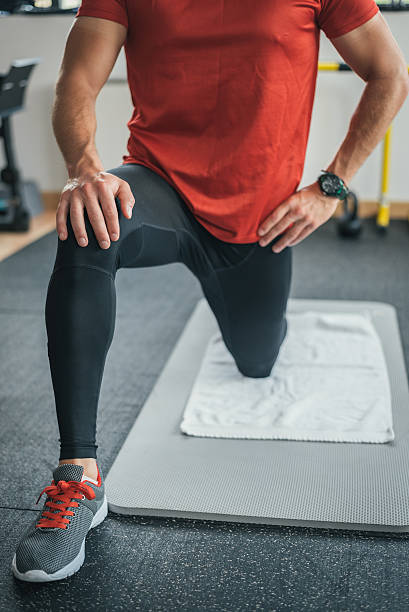 healthy man stretching leg before gym workout