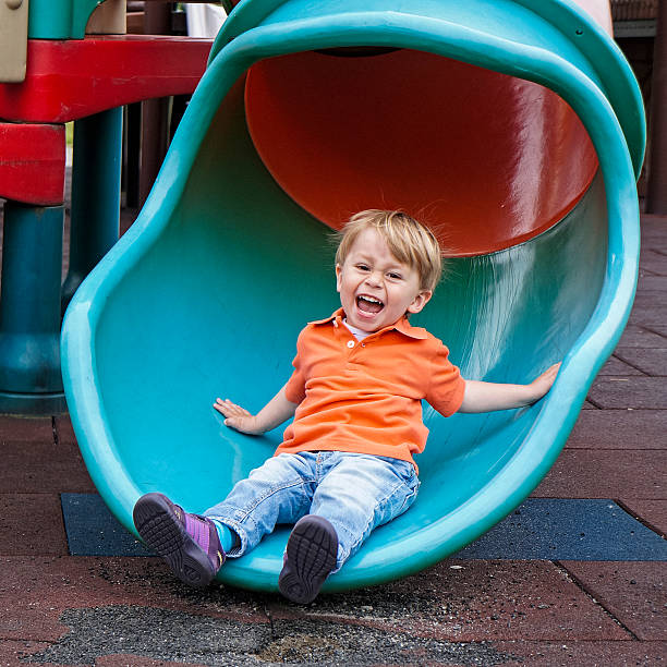 istock Cheerful little baby boy is having fun while sliding, playground 540098188