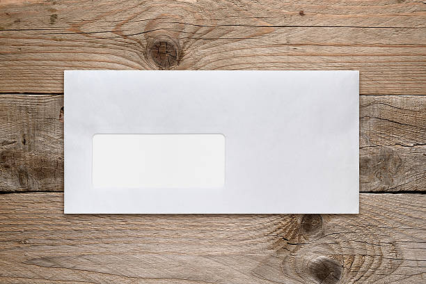 istock Blank envelope with address window on wooden table 540101526