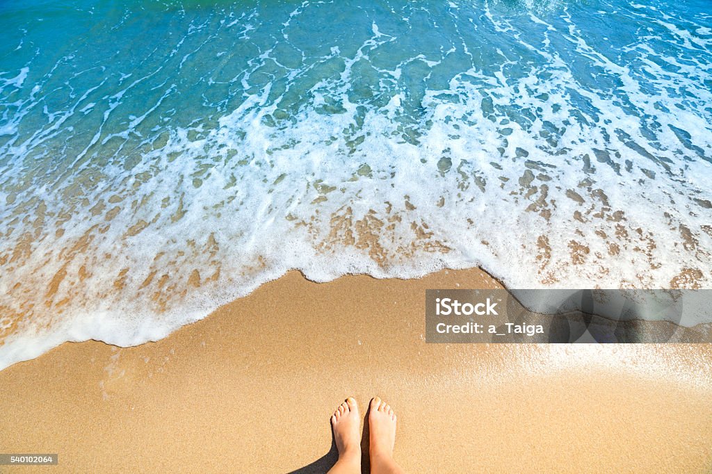 Sea foam, waves and naked feet on a sand beach Sea foam, waves and naked feet on a sand beach. Holidays, relax, summer background Sand Stock Photo