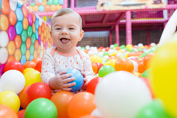 belle petite fille jouant avec des ballons colorés - playground cute baby blue photos et images de collection