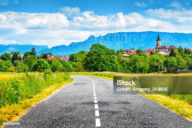 Empty Countryside Road With Old French Village And Alps Mountains Stock Photo - Download Image Now