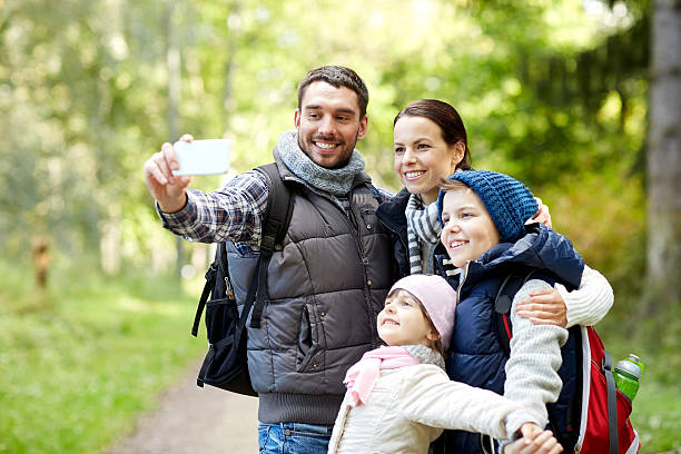istock family taking selfie with smartphone in woods 540111174