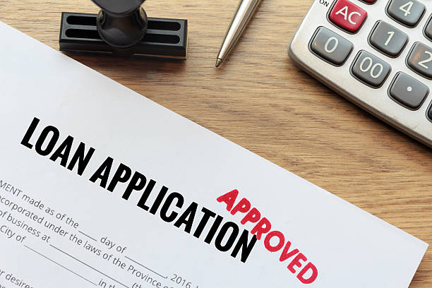Approved loan application with rubber stamp and calculator stock photo