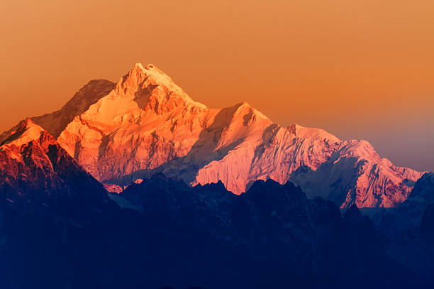 Sunrise on Mount Kanchenjugha, at Dawn, Sikkim Beautiful first light from sunrise on Mount Kanchenjunga, Himalayan mountain range, Sikkim, India. Orange tint on the mountains at dawn kangchenjunga stock pictures, royalty-free photos & images
