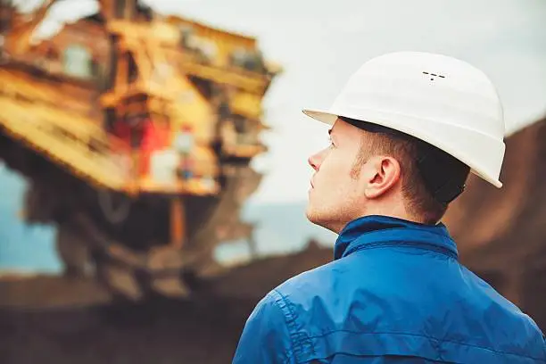 Coal mining in an open pit - Worker is looking on the huge excavator - industry in Czech Republic