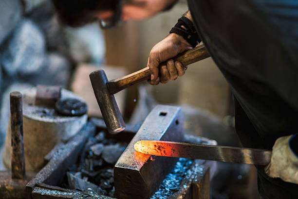 Blacksmith shaping a traditional Japanese cooking knife Blacksmith forging a traditional Japanese cooking knife. Kyoto, Japan. May 2016 knife weapon photos stock pictures, royalty-free photos & images