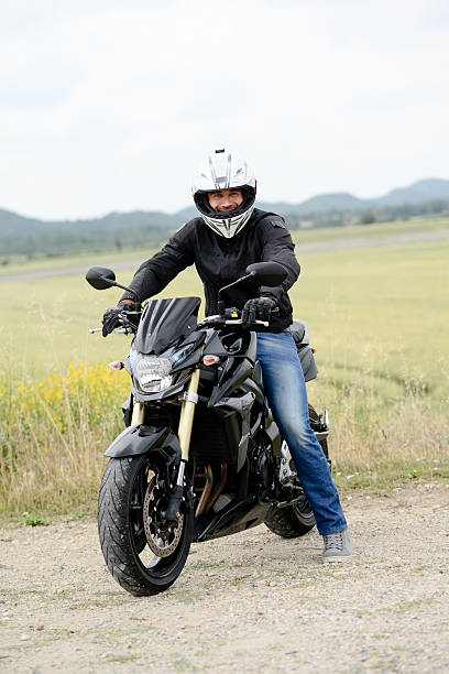istock handsome young man riding his black motorcycle 540117606