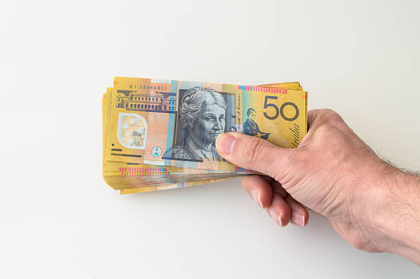 Man holding Australian Dollar banknote in his hands stock photo