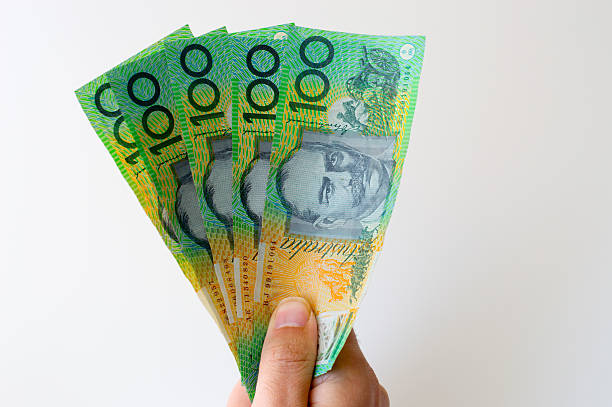 hombre que agarra cinco billete de banco de cien dólares australianos en sus manos - australian culture fotografías e imágenes de stock