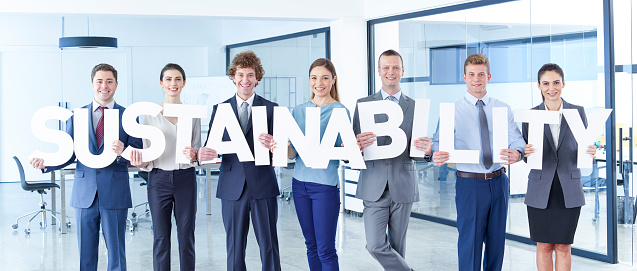 Business men and business women standing in office and holding letter. Sustainability.