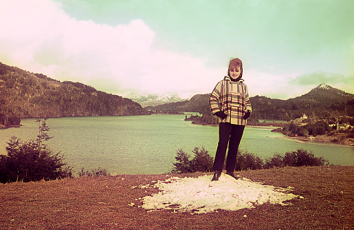 Vintage photo of a woman standing by a lake. Saturated colors. Original vintage slide.