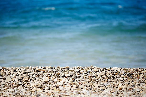 Small pebble on sea shore on a bright sunny day. Photo with shallow depth of field.